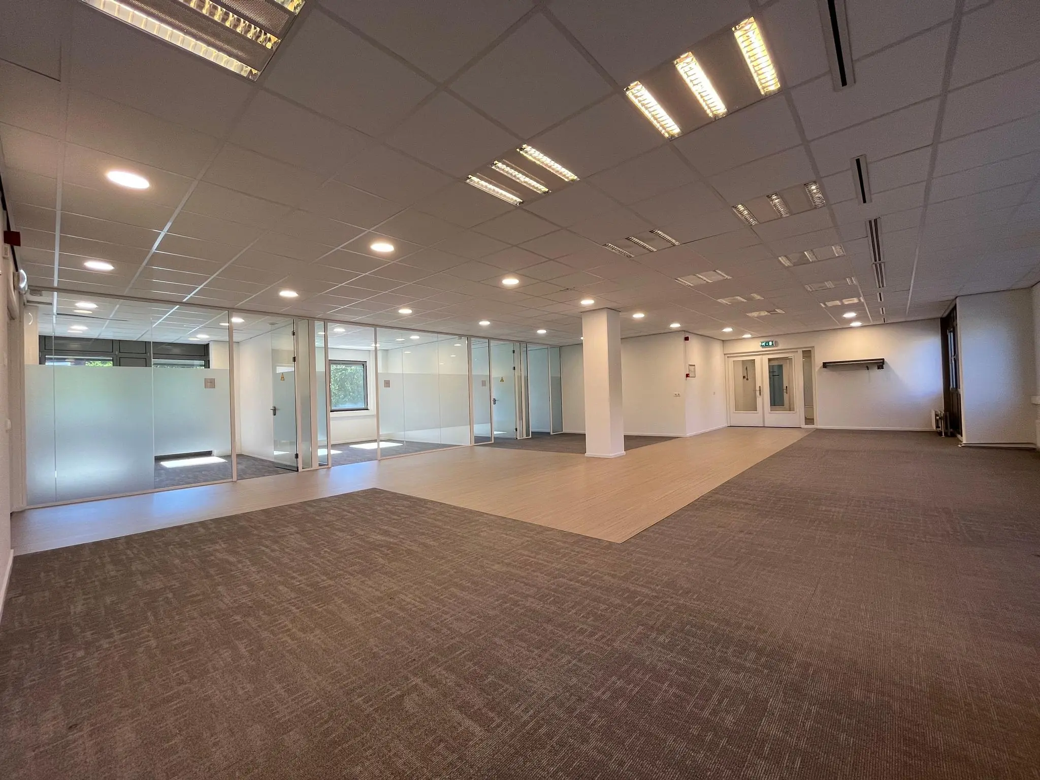 Moderne, ruime kantoorruimte aan de Barchman Wuytierslaan met glazen vergaderruimtes en systeemplafond.